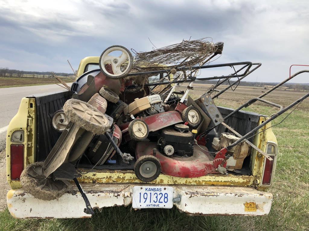 Antique Kansas truck bed loaded high with old broken lawn mowers — High Linn Farms